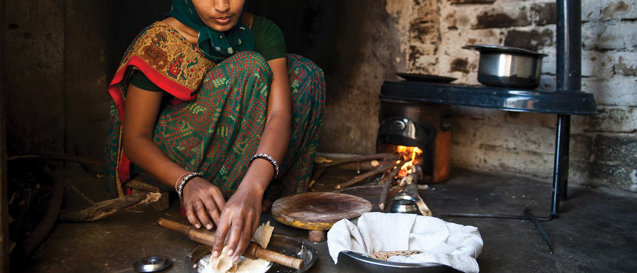 A woman prepares food on an improved cookstove in her home in the Indian state of Gujarat.