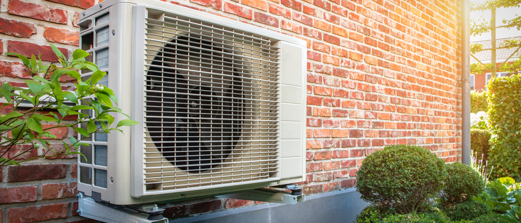 heat pump mounted on the exterior of a brick residence