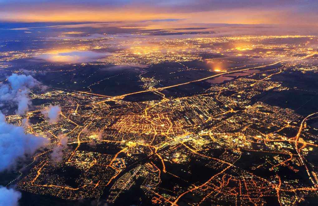 Aerial view of a city at night with glowing lights of buildings and streets