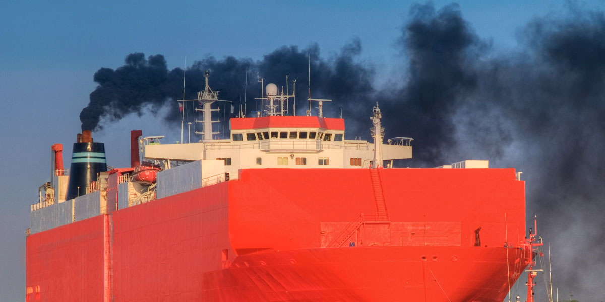 Cargo ship emitting thick black smoke