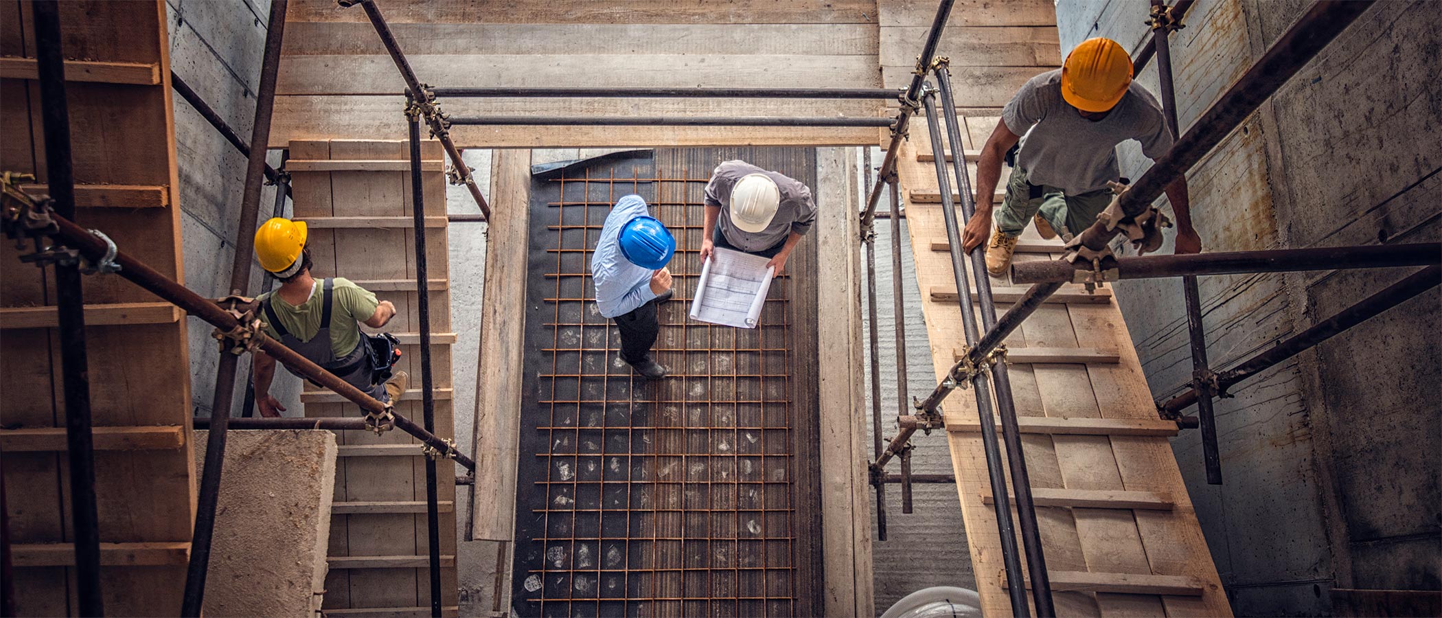 Construction workers and architects at a construction site viewed from above.