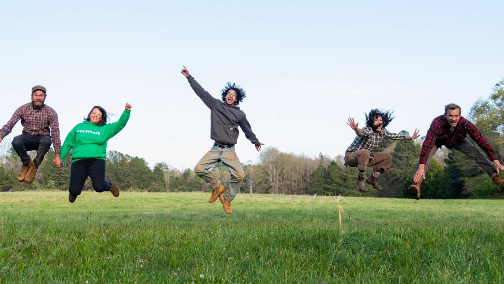 People jumping in a green field