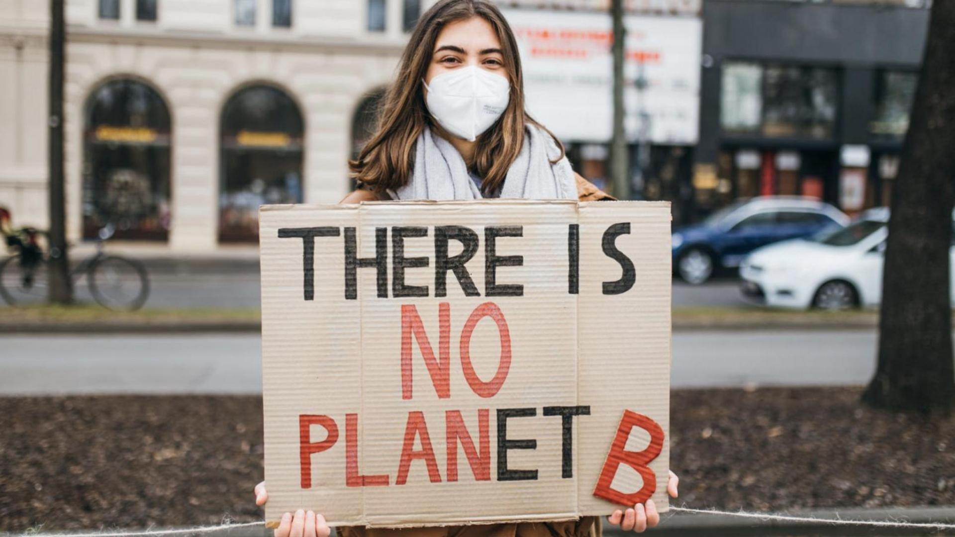 Person holding a sign that reads: There is No Planet B.