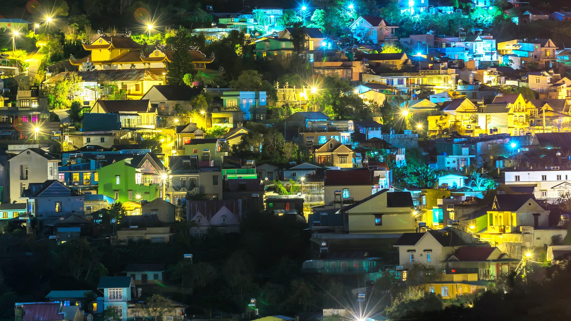 Neighborhood on a hill with lights on at night