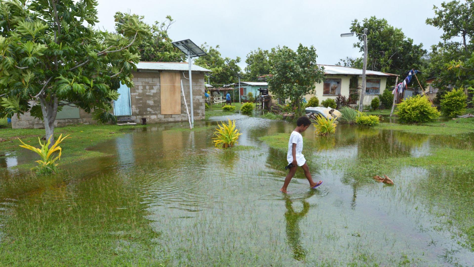 Indigenous Fijian girl walking on flooded land in Fiji