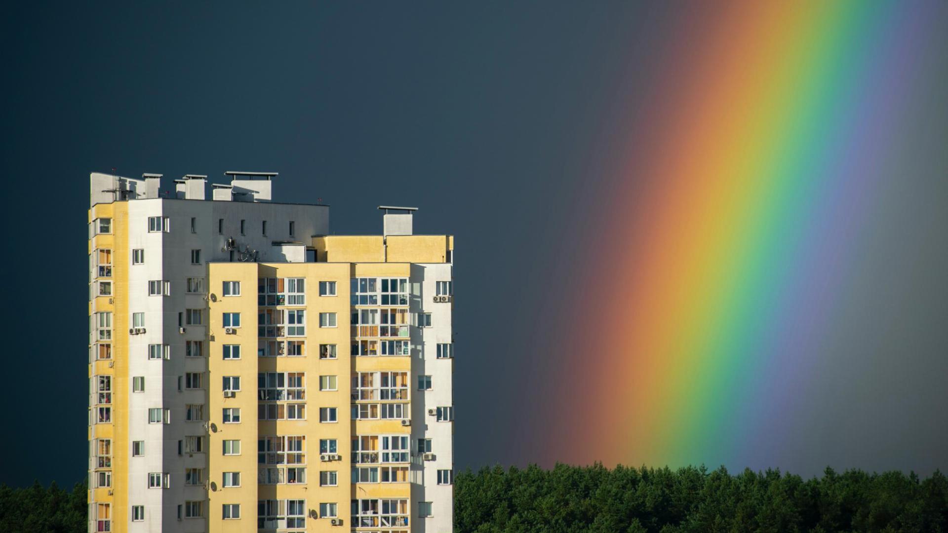 Rainbow over buildings and a forest